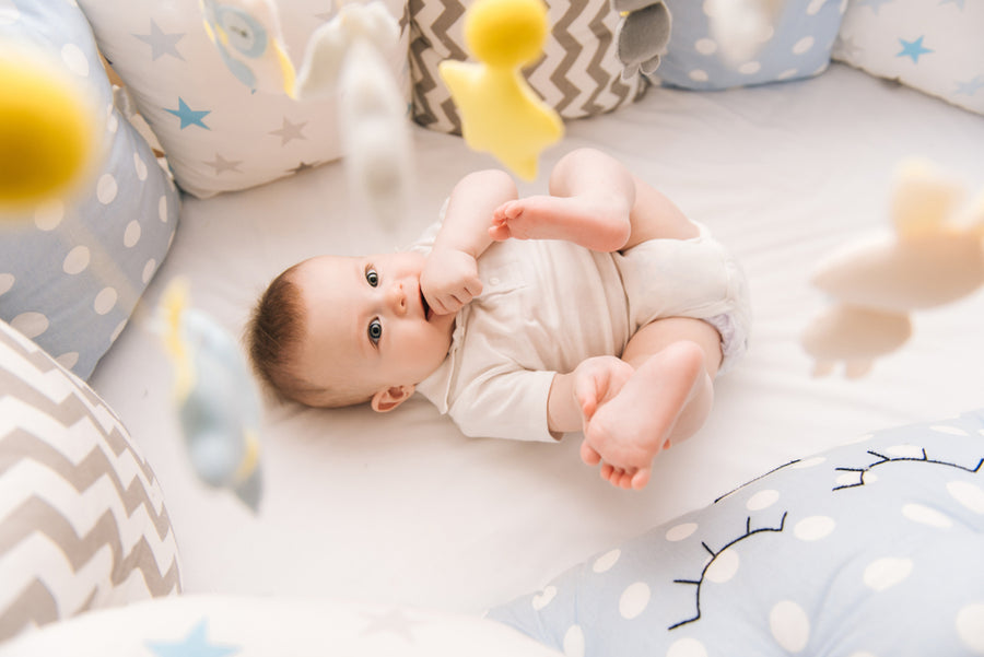 Cute baby lies in a white round bed