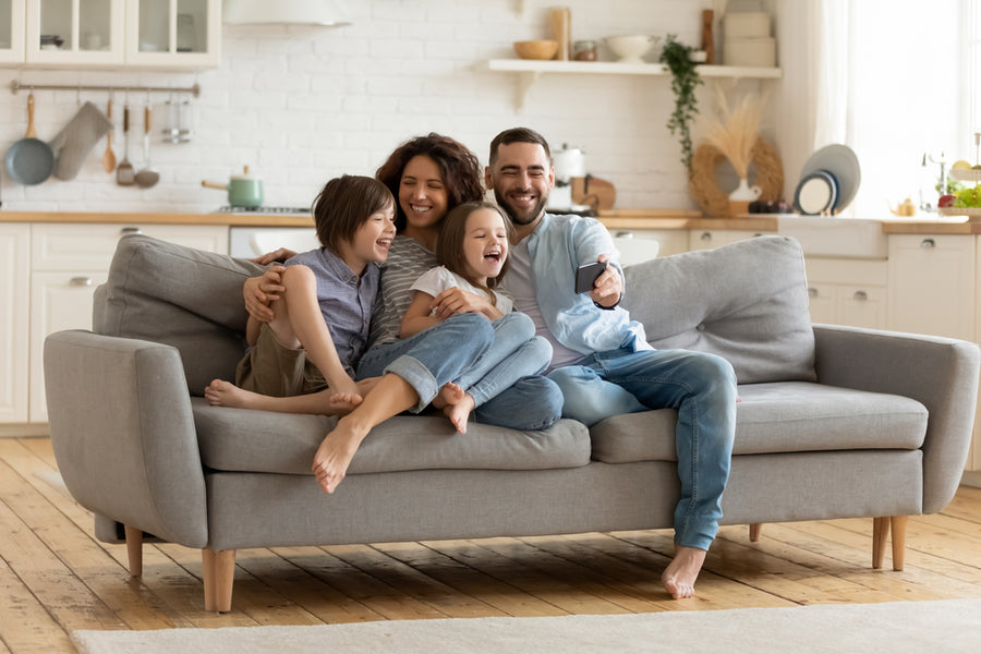 Excited parents looking at mobile screen with kids, feeling excited.