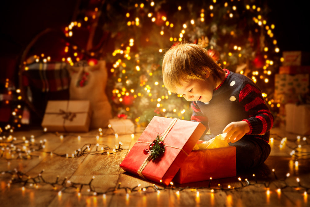 A child opening a presnt on Christmas morning.